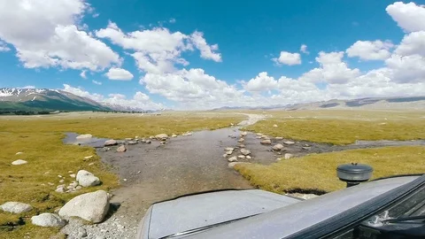 SUV moves across a deep river flow. Car rides on a mountain road. Auto travel Vídeos de archivo 110329308