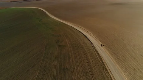 The SUV moves between the fields bypassing a woman pedestrian. Stock-Footage 139471573