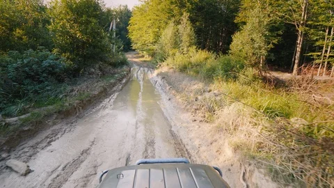 SUV is moving a big puddle on a bad road Stock Footage 104110002