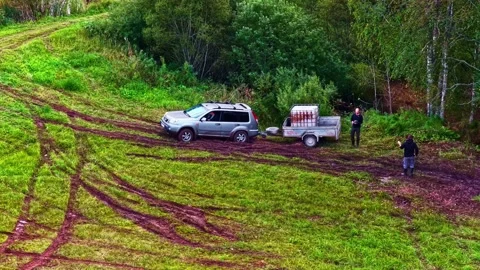 SUV pulling trailer stuck in muddy field aerial view resilience Stock Footage 333435311
