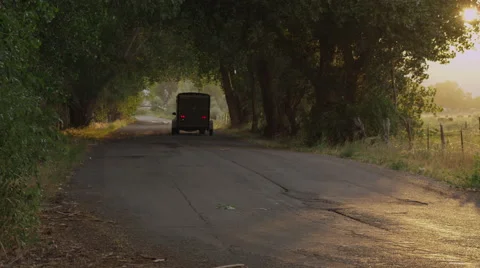 SUV Pulls Trailer down Tree Lined Tunnel Stock Footage 62654372