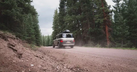 SUV Rear Drives Down Dirt Mountain Road Stock Footage 152784019
