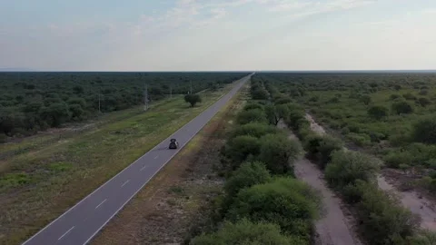 SUV on road trip crossing an empty straight desert highw Stock Footage 264095406