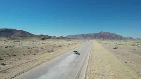 SUV Speeding With Dust Trail on Desert Road - Aerial Chase, Sesriem, Namibia Stock Footage 346540395