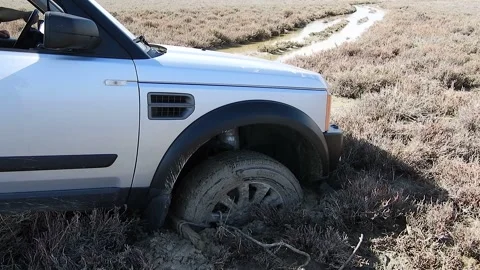 SUV stuck in deep mud struggles off road with wheel traction - Baglayp Camurdan Stock Footage 339793816