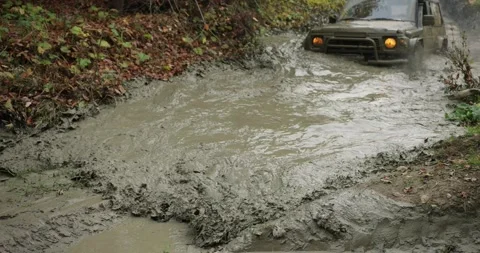 SUV is stuck on off road in mud puddle a... | Stock Video | Pond5