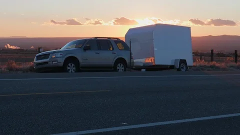 SUV With Trailer Pulled off the Side of the Road with Hazards Flashing Stock Footage 100796069