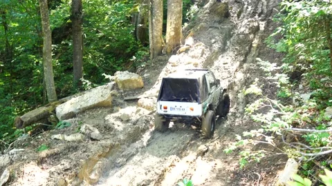 SUV trying to drive uphill through the mud Stock Footage 171469050