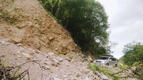 SUV Vehicles Navigating Mountain Road Damaged By Landslide In Remote Wilderness Stock Footage 346117639