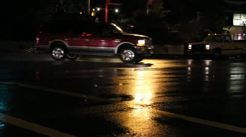 Suv's and trucks go through a rainy intersection at night Video stock 12174317