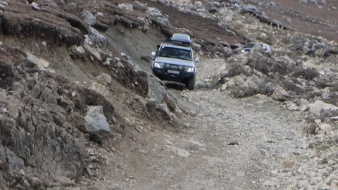 SUVs slowly move on mountain impassable road Stock Footage 252634676