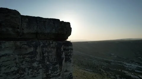 A swallow flies in front of the drone and the sun comes out from behind the rock Video stock 255908190