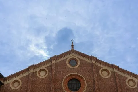 Swallows fly in the cloudy sky over the Basilica of Santa Maria delle Grazie Stock Photos