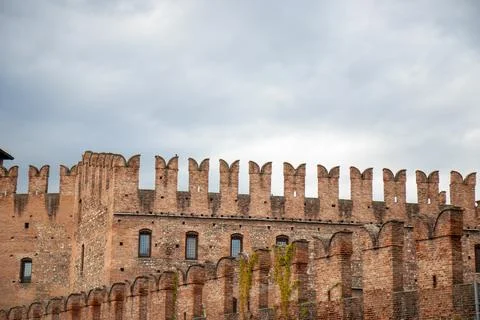 Swallowtail battlements or merlons and red brickwork of Castelvecchio, a medi Stock Photos