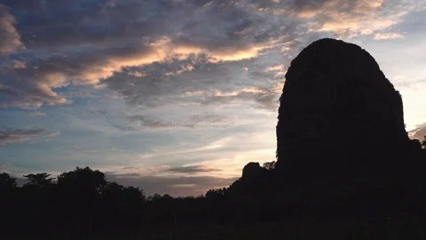 The swarm of bats fly in rows from the cave at sunset. Stock Footage 112682736