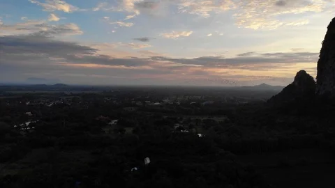 The swarm of bats fly in rows from the cave at sunset. Stock Footage 113072714