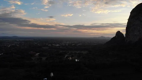 The swarm of bats fly in rows from the cave at sunset. Stock Footage 113624546