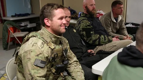 SWAT Trainees Talking around Table in Classroom Stock Footage 70563312