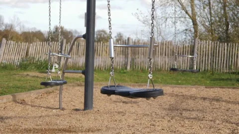 Swaying swing without children on an empty playground outdoors 2 Stock Footage 321616365