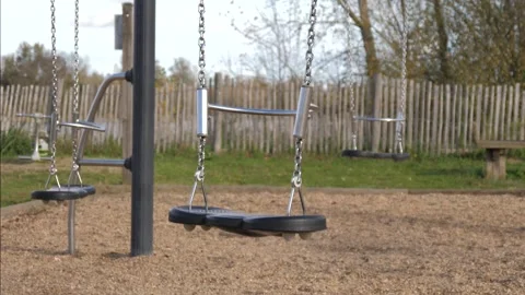 Swaying swing without children on an empty playground outdoors Stock Footage 321616396