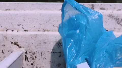 Swaying in the wind blue plastic bag stuck on a bridge railing,  representi.. Video stock 295901088