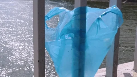 Swaying in the wind blue plastic bag stuck on a bridge railing,  representi.. Video stock 295901089