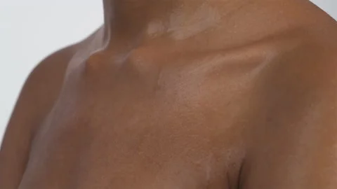 Sweat drops are flowing down on chest of unrecognizable black woman. Close-up. Stock Footage 133129389