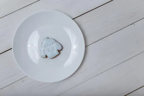 Sweater shape gingerbread cookie on white plate standing on white table Stock Photos
