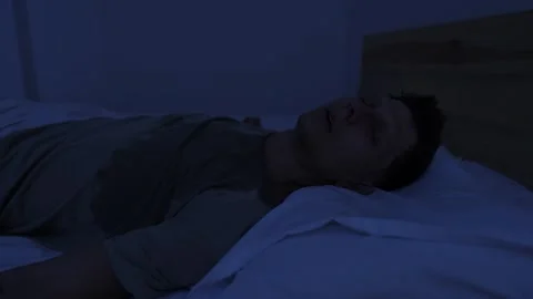 Sweating man suffering from night sweats and extreme heat, tossing in bed and Stock Footage 346249422