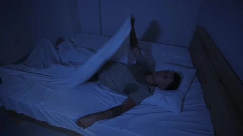 Sweating man suffering from night sweats, tossing in bed and throwing off covers Stock Footage 346251245