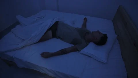 Sweating man tossing and turning in bed, restless and unable to sleep because of Stock Footage 346244472