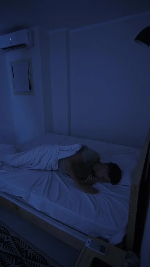 Sweating man tossing in bed and throwing off covers to cool down, unable to Stock Footage 346249142