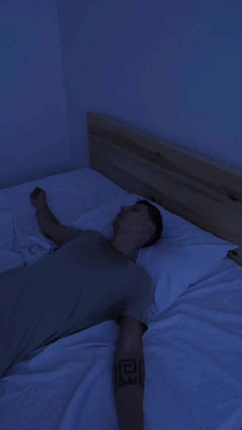 Sweating man tossing in bed and throwing off covers to cool down, unable to Stock Footage 346250520