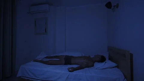 Sweating man unable to sleep during extreme heat, tossing and turning in bed on Stock Footage 346250016
