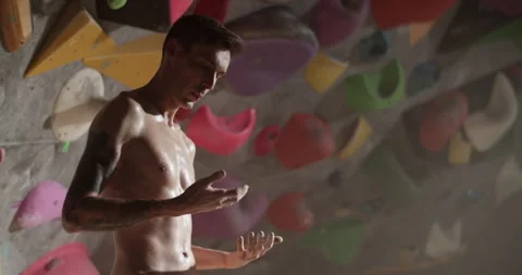 Sweating young man climber standing in gym Stock Footage 259984793