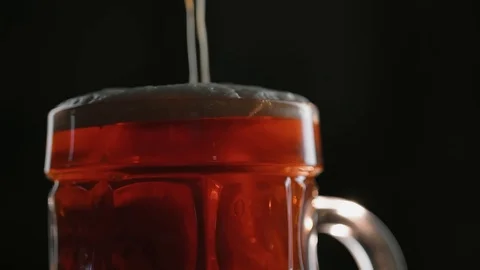 Sweaty mug of cold dark kraft beer with overflowing foam, in bar or pub, 50 fps Stock Footage 94585337