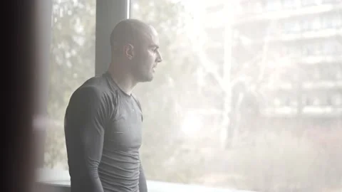Sweaty Tired Fighter Looking Through Window After a Workout Stock Footage 174929144