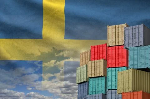 Sweden flag and big stack of shipping cargo containers in docks with sky Foto stock