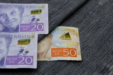 Swedish banknotes of different denomination between blue denim fabric Stock Photos