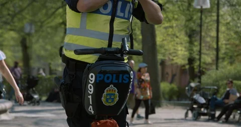 Swedish cop on a segway using his walkie talkie in Mariatorget park. Vidéo 94598474
