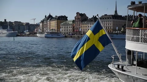Swedish flag foating in the wind at the end of boat at the docks in Stockholm Video stock 159564443