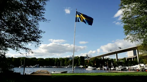 Swedish flag in front of bridge waving in slow motion fully flared 1028 Vidéo 50342628