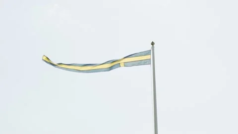 Swedish flag on a long pole waving in the wind on a sunny day Stock Footage 235152907