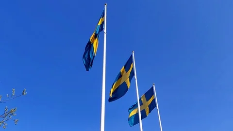 Swedish flag waving slowmotion under the blue sky in flagpoles during the nation Stock Footage 108122853