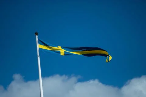 Swedish flags waving with the wind flow under the blue sky Stock Photos