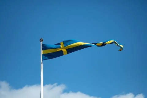 Swedish flags waving with the wind flow under the blue sky Stock Photos