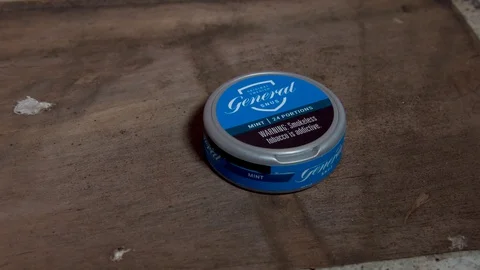 Swedish Snus - Dropping onto Wood Backdrop Stock Footage 128611653