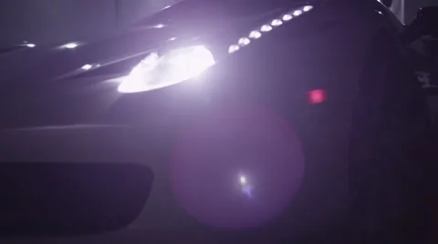 Sweep across the front of high end sports car with headlights on. Stock Footage 64288705