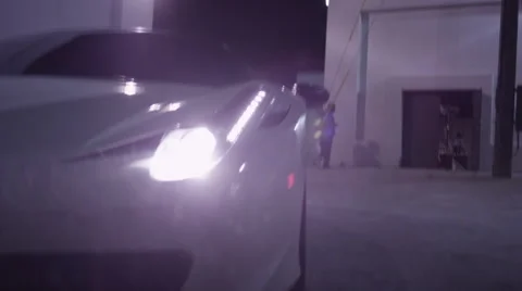 Sweep across the front of a high-end Porsche as it reverses. Stock Footage 64290217