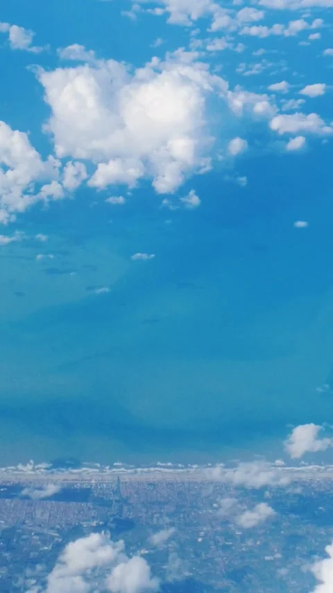 Sweep wing plane air thick clouds below land towns sides ocean meeting horizon Stock Footage 321255853